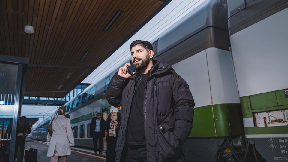 Mies puhumassa puhelimeen Joensuun juna-asemalla