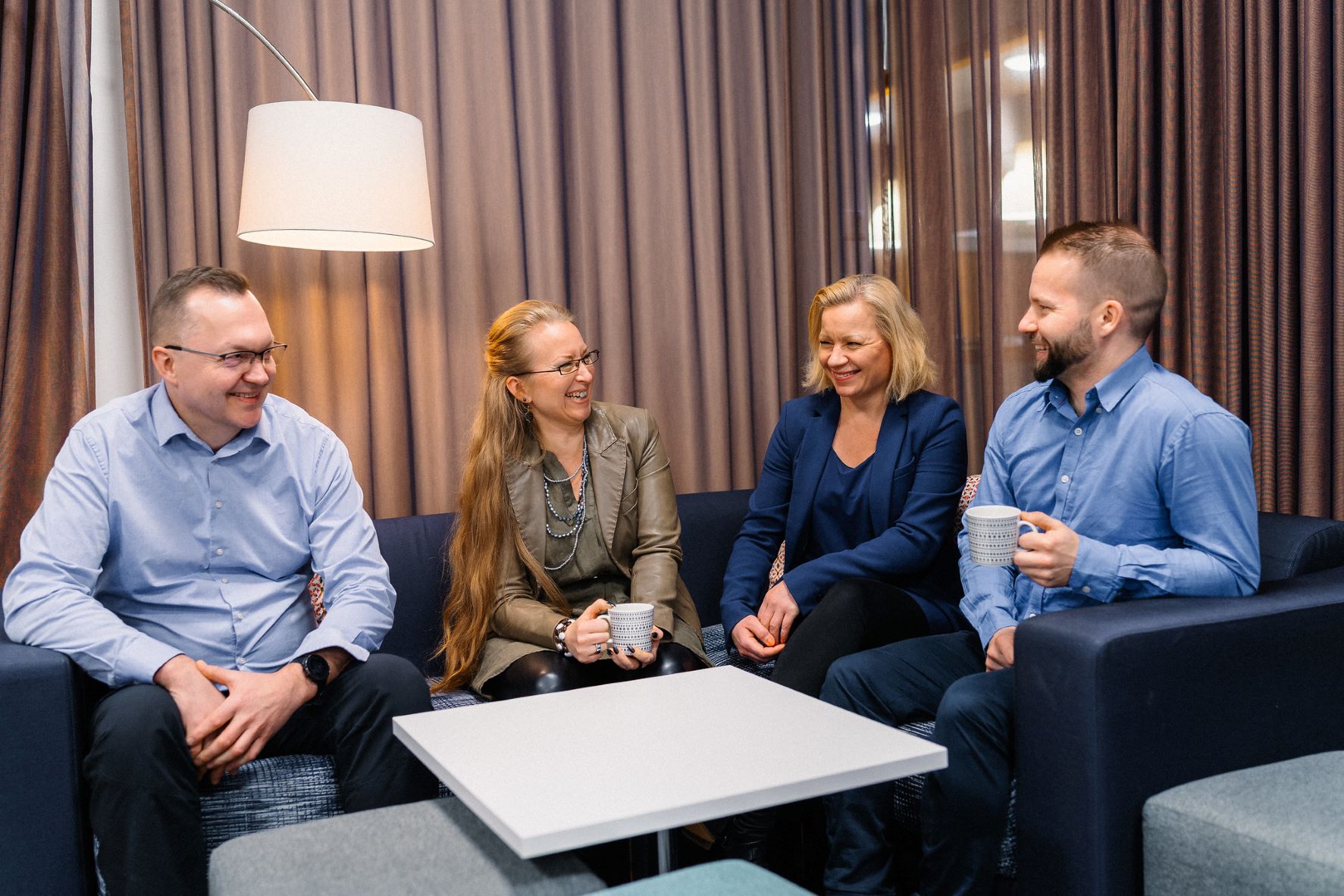 Business_Joensuu_kansainvälistyminen_neljä_ihmistä_sohvalla_kahvikuppeja_käsissä_photo_Harri_Säynetvirta