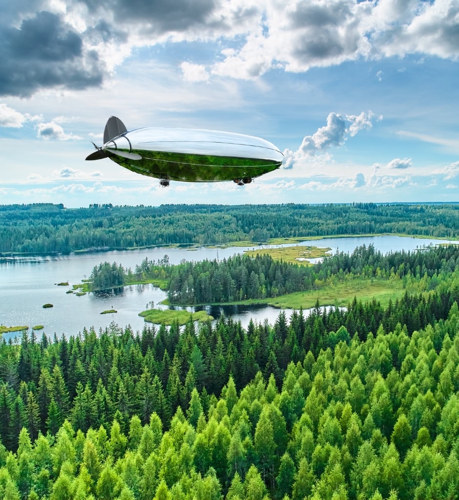Investments and relocation services in Joensuu | Business Joensuu | Kelluu Oy's airship above a forest and a lake