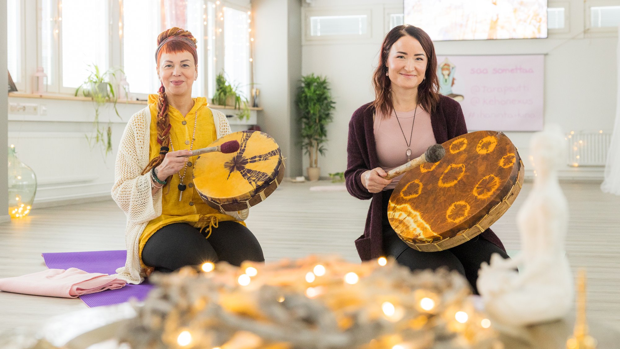 Geneesi Tara Tuomisilta ja Maiju Rissanen. Kaksi naista soittamassa shamaanirumpuja. | Business Joensuu, yrityspalvelut